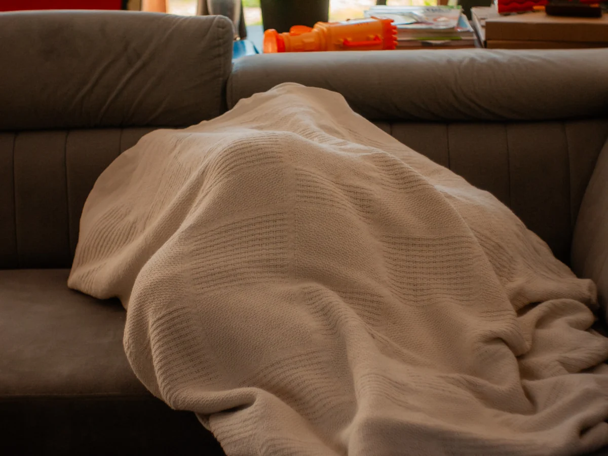 Guest relaxing under a blanket to represent comfort reliability persona